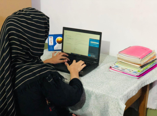 دانش‌آموز افغان در حال یادگیری آنلاین با لپ‌تاپ